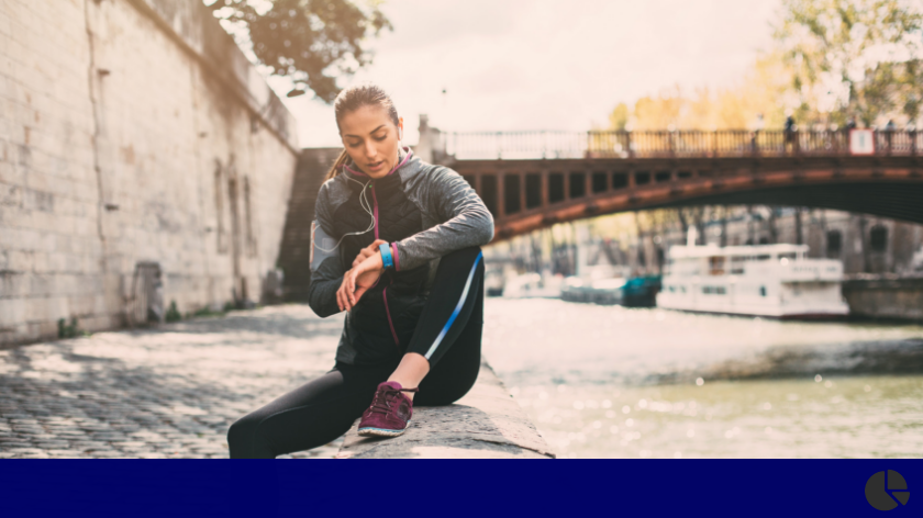 Woman checking fitness tracker during outdoor workout - Vitality