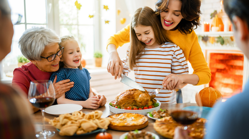 Family carving turkey for holiday dinner to give family health history - Vitality