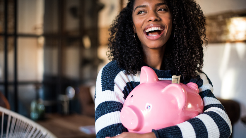 Woman holding piggy bank for financial fitness - Vitality