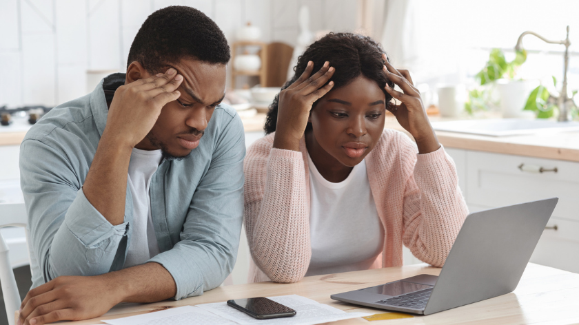 People assessing finances on laptop computer to work through money problems - Vitality