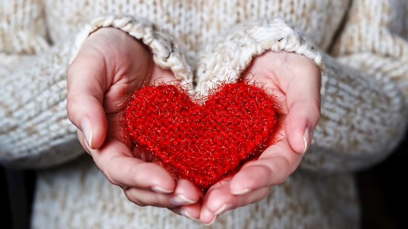 Woman in sweater holding red heart for steps to a healthy heart - Vitality