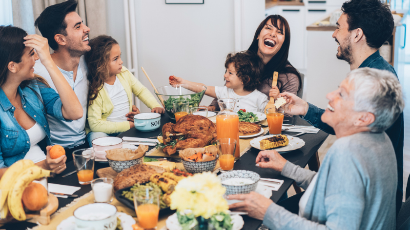 Family enjoying holiday dinner laughing - Vitality