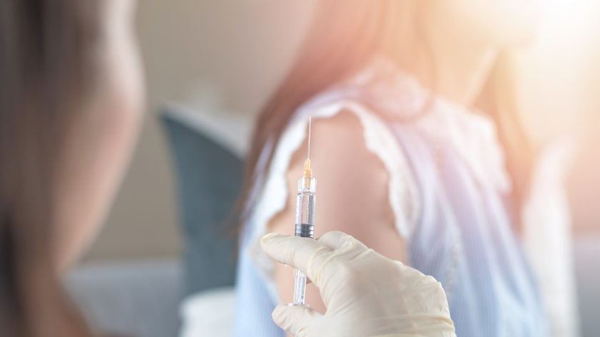 Health professional prepares to give woman shot vaccination - Vitality