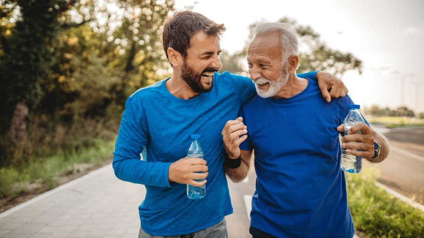 Two fit men being active outdoors on a trail drinking water - Vitality