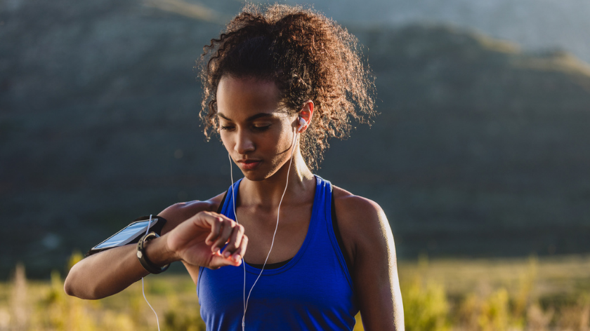 Woman exercising outside checking device - Vitality