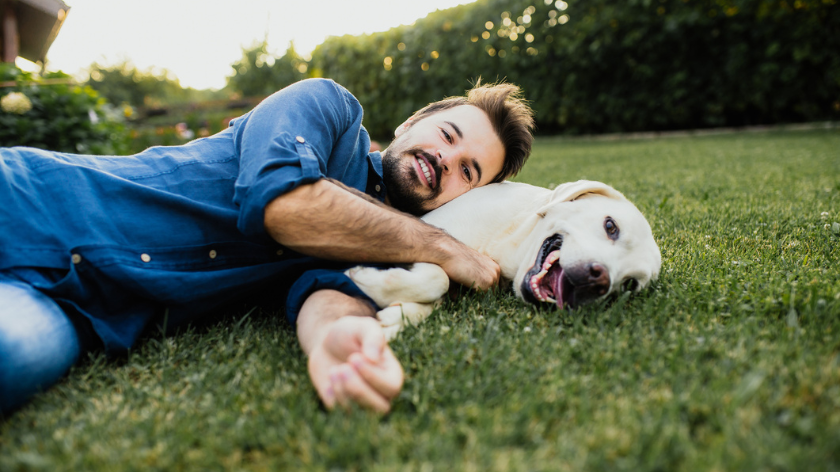 Man with dog relaxing outdoors for a reward - Vitality