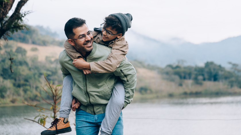 Father and son oudoors smiling to stay healthy during holiday season - Vitality