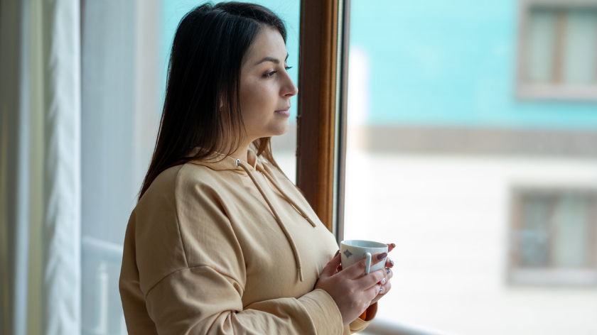 Woman Looking out window for sustaining mental wellbeing - Vitality
