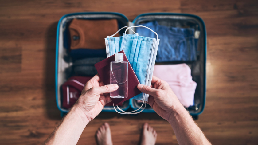 Packing suitcase with face mask, sanitizer for resuming safe travel on the road - Vitality