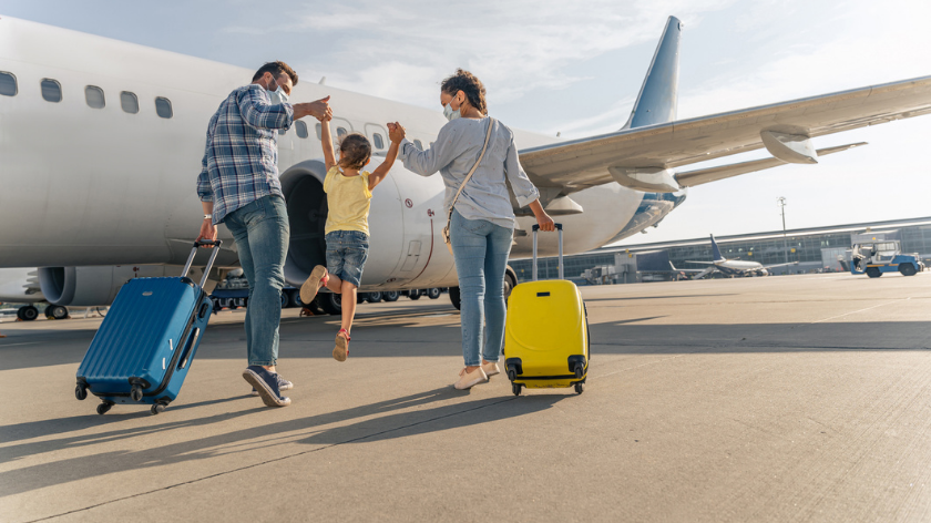 Family wearing face masks traveling for spring break on plane during COVID - Vitality