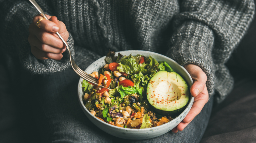 Woman eating salad with avocado for health on World Obesity Day - Vitality