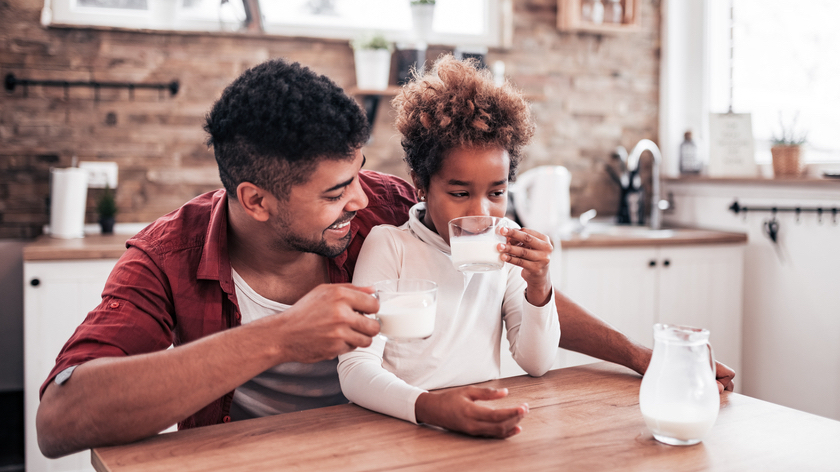 Girl and father in kitchen drinking milk for new drink recommendation release - Vitality
