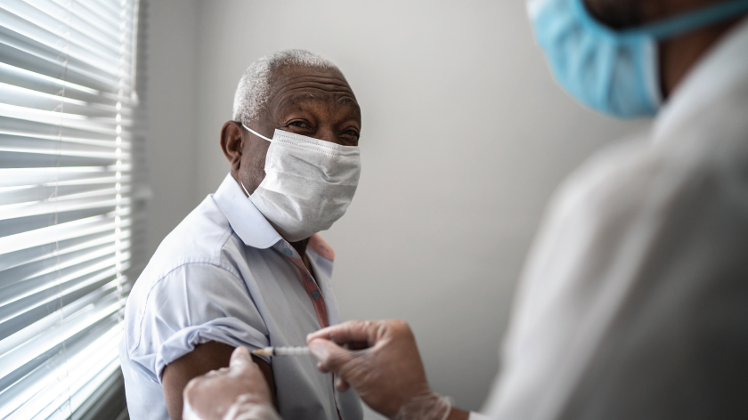 Senior man getting vaccine from health professional - Vitality