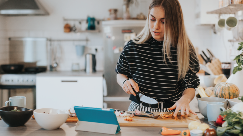 Woman cooking healthy meal in kitchen following social class - Vitality