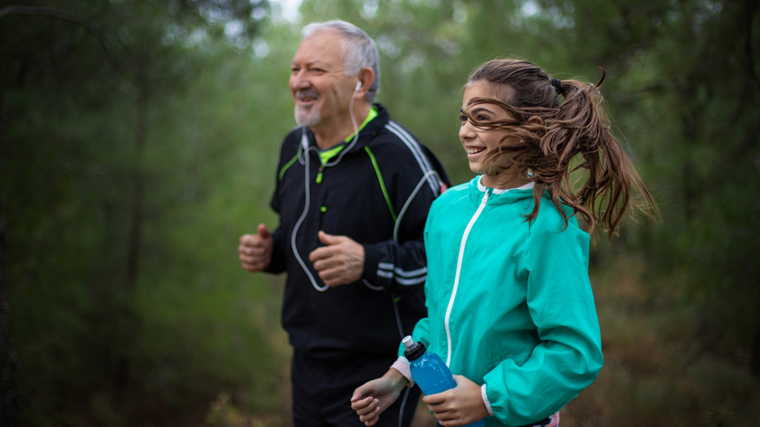 senior man and young girl jogging outside to bridge the generational divide with physical activity - Vitality
