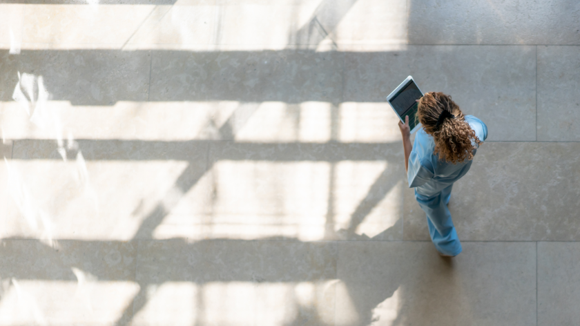 Nurse reading tablet outside to stop spread of COVID-19 - Vitality