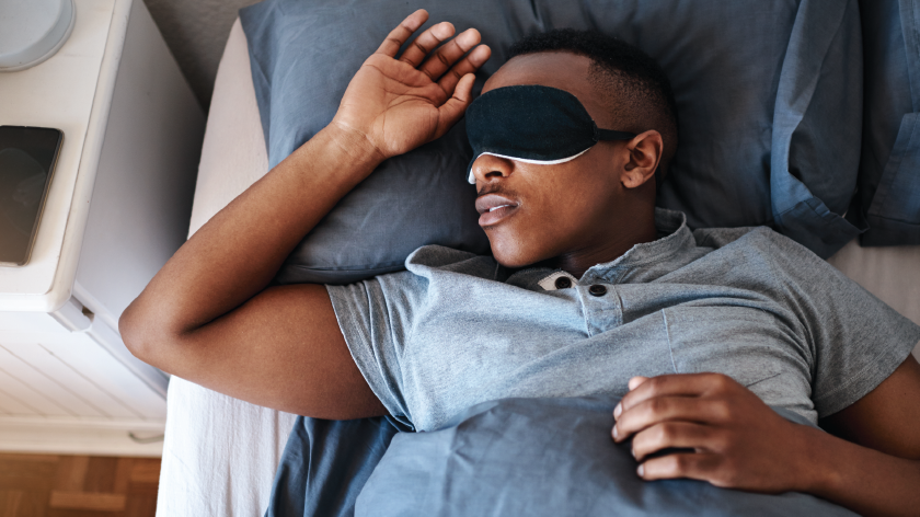 Man in bed with eye mask knows the importance of sleep - Vitality