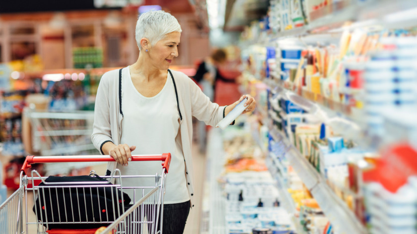 Senior woman grocery shopping reading food labels - Vitality