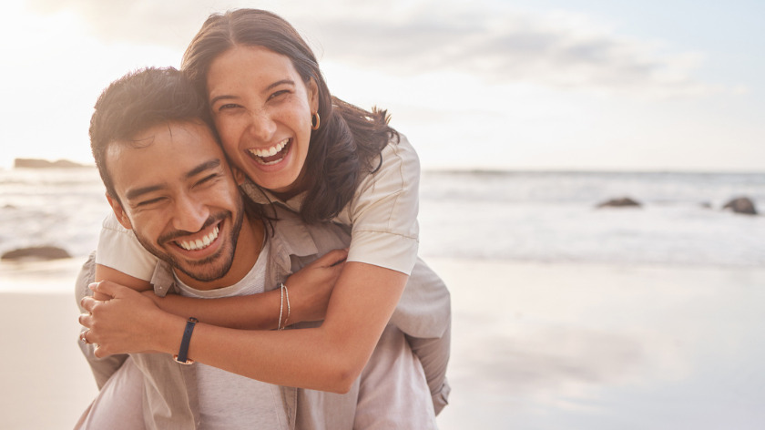 young couple hugging on beach for new year goals