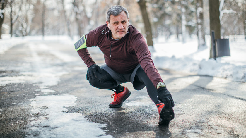 Senior Man Stretching Before Workout Shows How To Win at Winter Workouts