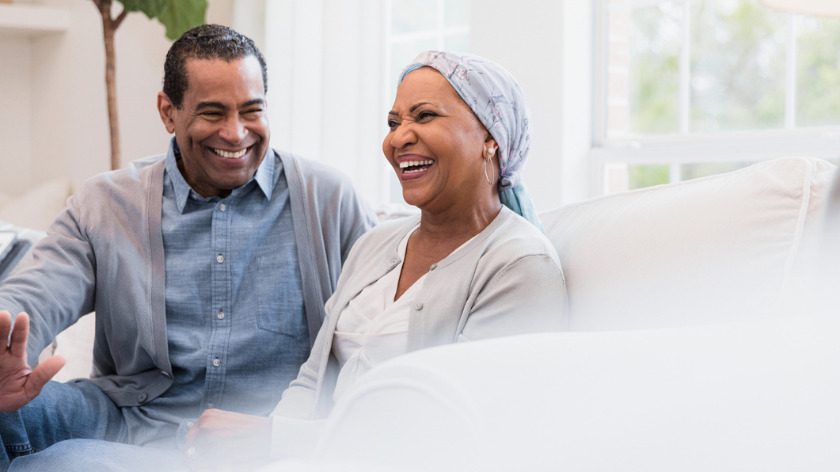 Female cancer patient smiling on couch with man - Vitality